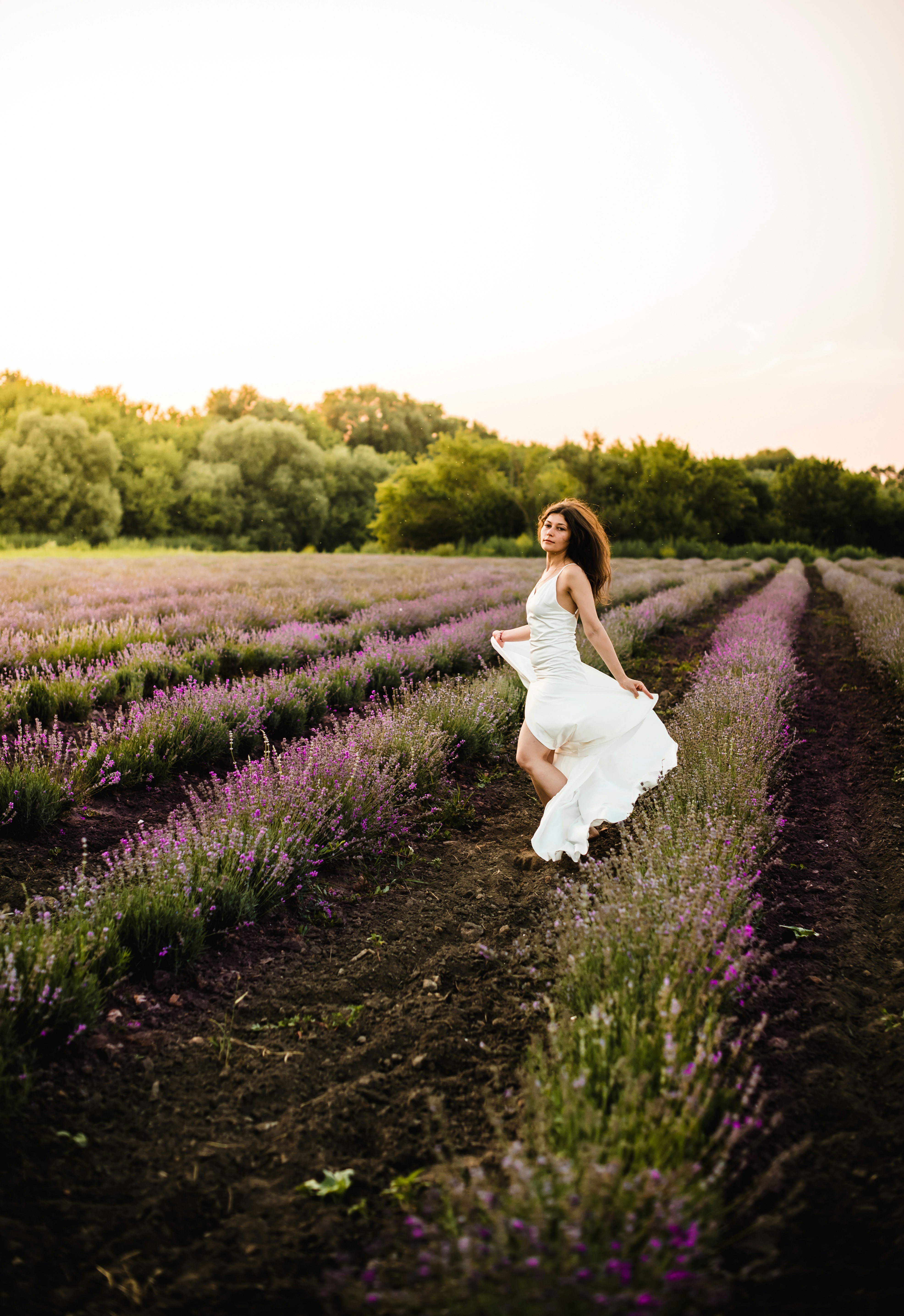 woman in white dress standing on green grass field during daytime